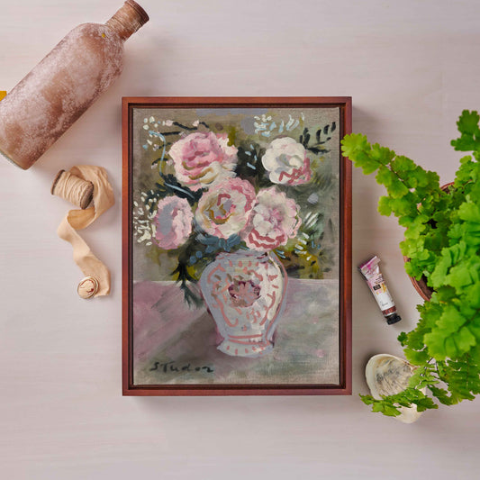 Framed painting of flowers on a table with decorative items.